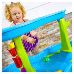 Vue rapprochée d'un enfant jouant avec les douches à effet de pluie Step 2 Direct et la nappe phréatique de l'étang