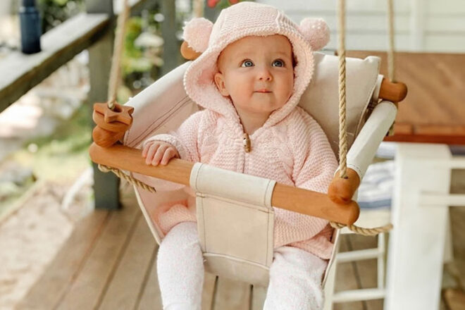 Jeune fille assise dans une balançoire pour tout-petit de Swingz n Thingz