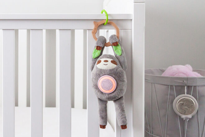Aide-sommeil Santi le paresseux suspendu à un lit d'enfant sur un anneau