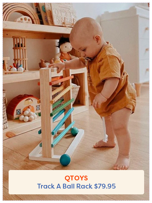 Bébé debout à côté du jouet QToys Track a Ball